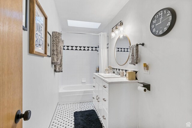 full bath with shower / tub combo, a skylight, vanity, and tile patterned flooring