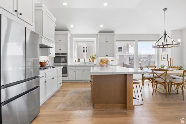 4947 W Evergreen Ln, Highland, UT 84003 - kitchen featuring light countertops, light wood-style flooring, a kitchen island, and appliances with stainless steel finishes