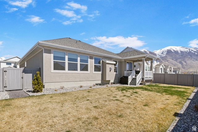 4947 W Evergreen Ln, Highland, UT 84003 - rear view of property featuring a gate, fence, ceiling fan, a mountain view, and a yard