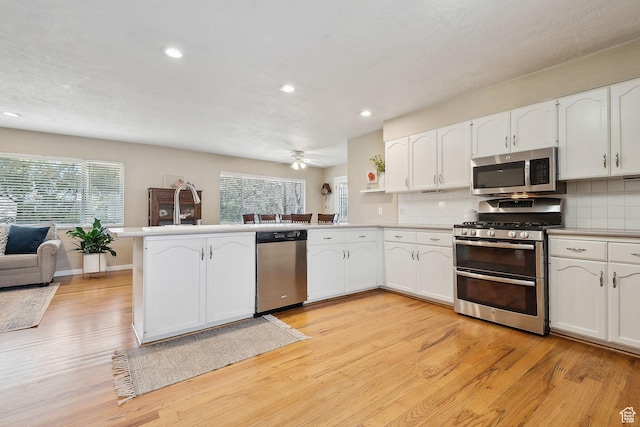 32 E 500 S, Midway, UT 84049 - kitchen with stainless steel appliances, a sink, a peninsula, recessed lighting, and light wood-type flooring