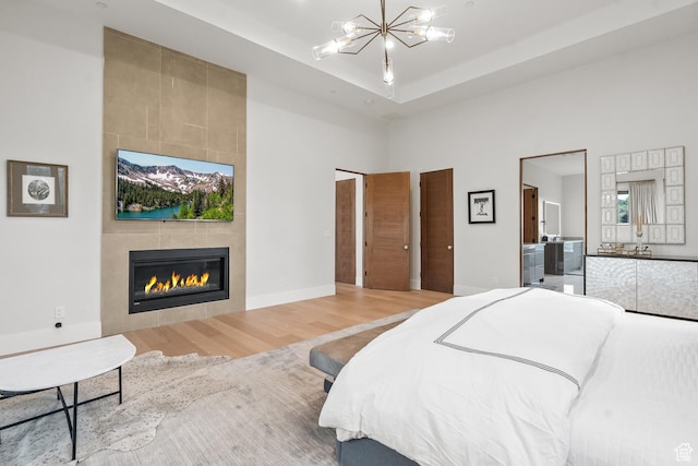 7290 Foxglove Ct, Park City, UT 84098 - bedroom with a tile fireplace, a chandelier, wood finished floors, baseboards, and a towering ceiling