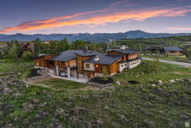 7290 Foxglove Ct, Park City, UT 84098 - back of property at dusk with a patio, a chimney, and a mountain view