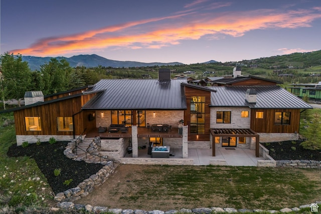 7290 Foxglove Ct, Park City, UT 84098 - back of house at dusk featuring metal roof, a chimney, a standing seam roof, a mountain view, and a patio area