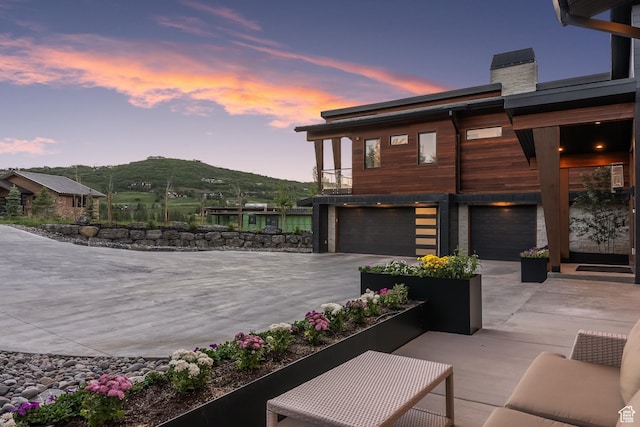 7290 Foxglove Ct, Park City, UT 84098 - exterior space featuring concrete driveway, a garage, a mountain view, and a chimney