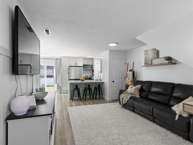 1929 W 680 N, Pleasant Grove, UT 84062 - living area with baseboards, visible vents, light wood-style floors, and a textured ceiling