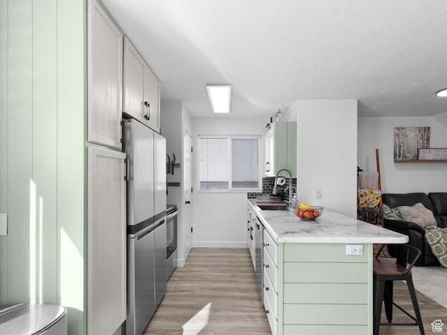 1929 W 680 N, Pleasant Grove, UT 84062 - kitchen featuring open floor plan, a kitchen bar, light wood-type flooring, a sink, and appliances with stainless steel finishes