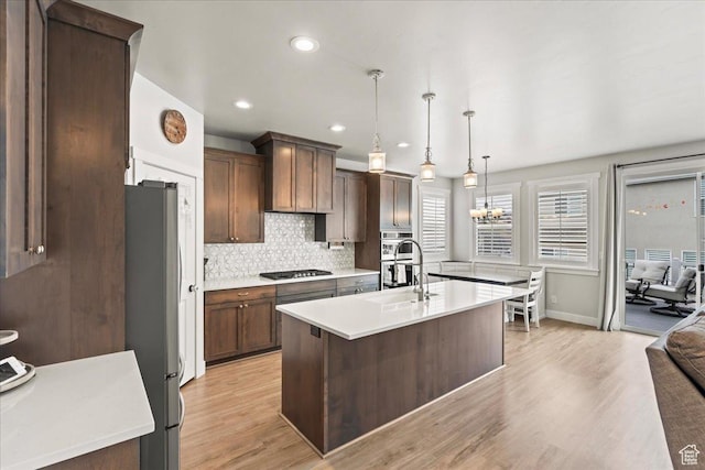 1321 E Daffodil Ct N Unit 155, Layton, UT 84040 - kitchen with light countertops, a sink, stainless steel appliances, and a notable chandelier