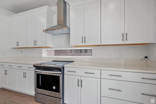 217 S Buckhorn Bath Ave W, Saratoga Springs, UT 84045 - kitchen featuring light countertops, white cabinetry, wall chimney exhaust hood, electric stove, and light wood-style floors