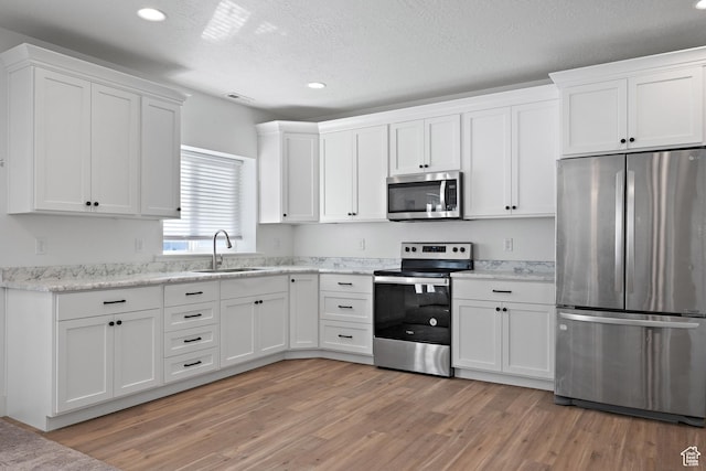 1807 S Bridle Path Loop, Lehi, UT 84043 - kitchen featuring appliances with stainless steel finishes, recessed lighting, a sink, white cabinetry, and light wood-type flooring