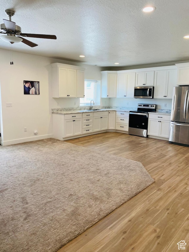 1807 S Bridle Path Loop, Lehi, UT 84043 - kitchen with a ceiling fan, light wood finished floors, a sink, white cabinetry, and stainless steel appliances