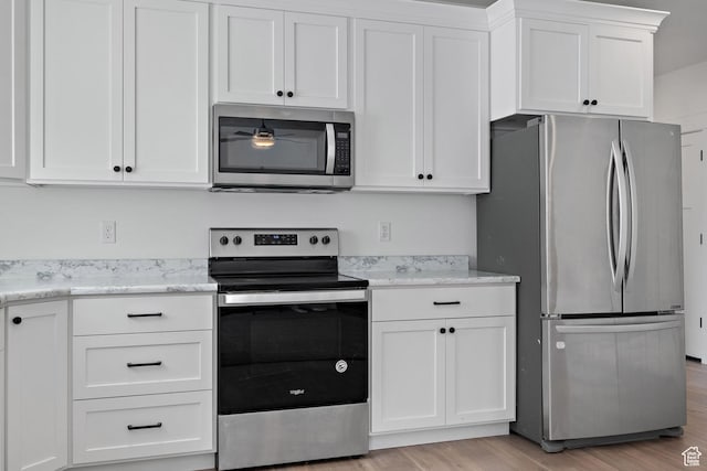 1807 S Bridle Path Loop, Lehi, UT 84043 - kitchen featuring light wood finished floors, appliances with stainless steel finishes, light stone countertops, and white cabinets