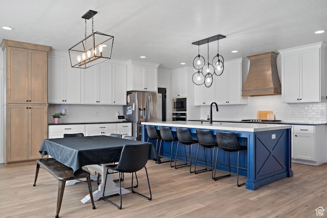 1807 S Bridle Path Loop, Lehi, UT 84043 - kitchen featuring an inviting chandelier, premium range hood, decorative backsplash, stainless steel appliances, and a kitchen island with sink