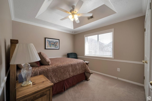 bedroom with a raised ceiling, light carpet, baseboards, visible vents, and ornamental molding