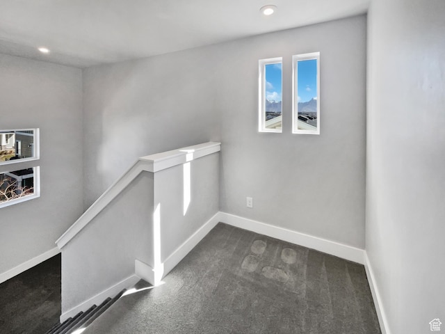 interior space with baseboards, dark carpet, and recessed lighting