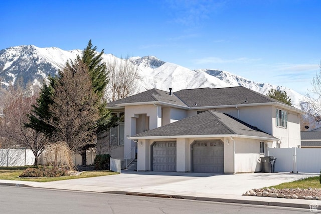 view of front of home featuring driveway, a mountain view, and an attached garage