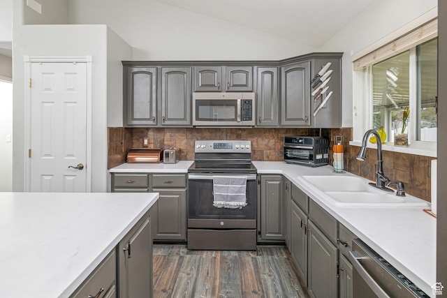444 E 2720 N, North Logan, UT 84341 - kitchen featuring appliances with stainless steel finishes, gray cabinetry, a sink, vaulted ceiling, and dark wood-style flooring