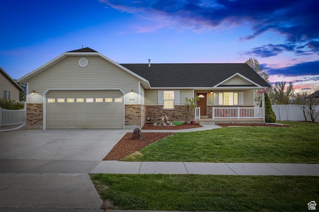 ranch-style house featuring an attached garage, concrete driveway, brick siding, covered porch, and a yard