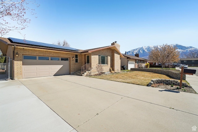 240 W 220 S, Orem, UT 84058 - view of front of home featuring driveway, solar panels, a mountain view, and a chimney
