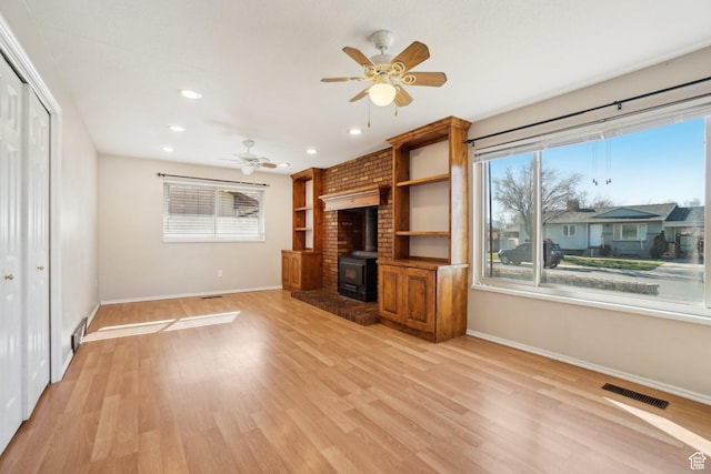240 W 220 S, Orem, UT 84058 - unfurnished living room featuring a ceiling fan, visible vents, a healthy amount of sunlight, and a wood stove