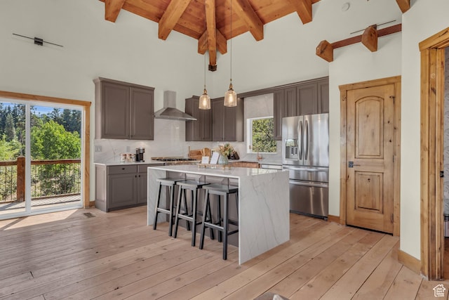 2421 S Navajo Unit Pi-C50, Coalville, UT 84017 - kitchen with stainless steel fridge with ice dispenser, decorative backsplash, a kitchen island, light wood-style floors, and wall chimney exhaust hood