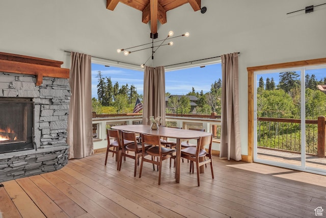 2421 S Navajo Unit Pi-C50, Coalville, UT 84017 - dining area featuring hardwood / wood-style floors, a stone fireplace, an inviting chandelier, and lofted ceiling with beams