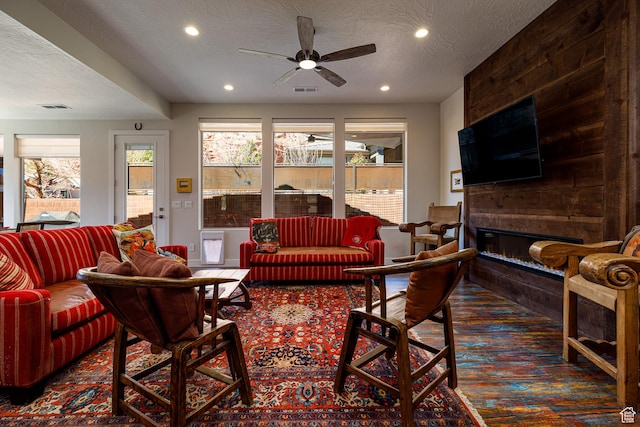 533 E Cutter Trl, Kanab, UT 84741 - carpeted living room featuring a textured ceiling, a large fireplace, visible vents, and a ceiling fan