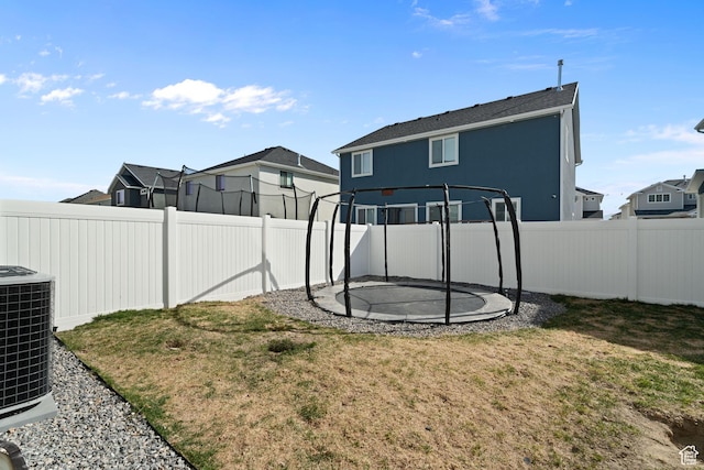 7016 N Amber Mead Ave, Eagle Mountain, UT 84005 - view of yard with a trampoline, a fenced backyard, central AC, and a residential view