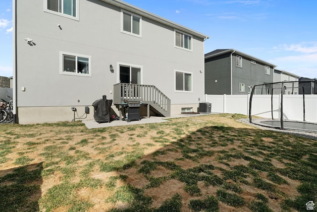7016 N Amber Mead Ave, Eagle Mountain, UT 84005 - back of property with a trampoline, central air condition unit, fence, a patio, and a yard