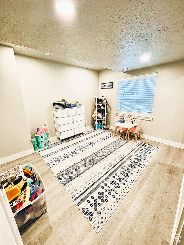 7016 N Amber Mead Ave, Eagle Mountain, UT 84005 - playroom featuring baseboards, a textured ceiling, and wood finished floors