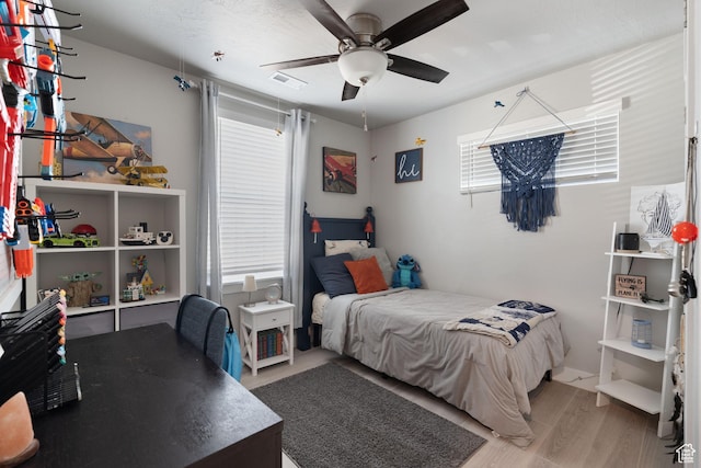 7016 N Amber Mead Ave, Eagle Mountain, UT 84005 - bedroom featuring light wood-style flooring, visible vents, multiple windows, and ceiling fan