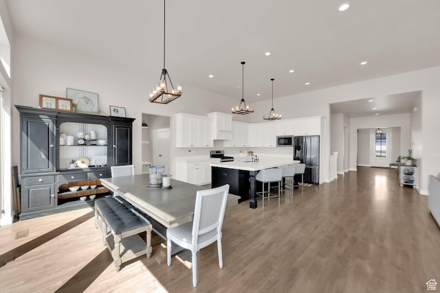 2266 S Betsys Way, Kaysville, UT 84037 - dining area with a chandelier, light wood-style flooring, a high ceiling, and recessed lighting