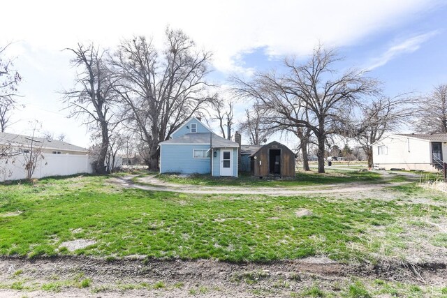 view of yard featuring fence, a storage shed, and an outdoor structure