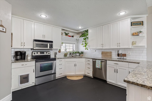 kitchen featuring a sink, white cabinets, appliances with stainless steel finishes, and open shelves