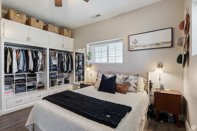 bedroom with a ceiling fan, dark wood finished floors, and visible vents