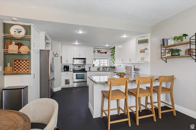 kitchen featuring white cabinetry, open shelves, a peninsula, and appliances with stainless steel finishes