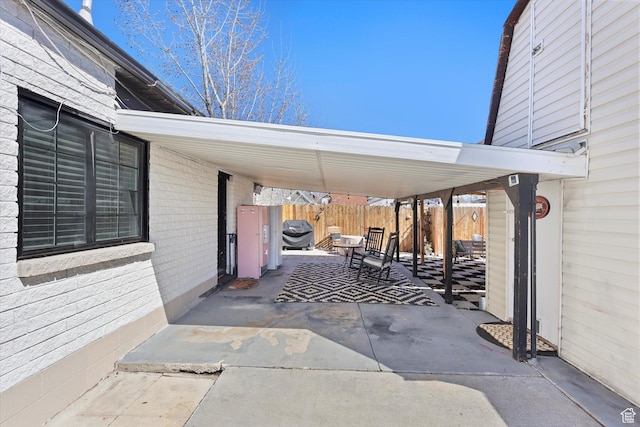 view of patio / terrace with an attached carport, a grill, and fence