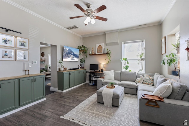 living room featuring dark wood-type flooring, ceiling fan, visible vents, and ornamental molding