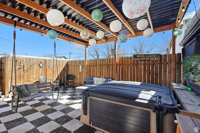 view of patio / terrace with fence and a hot tub