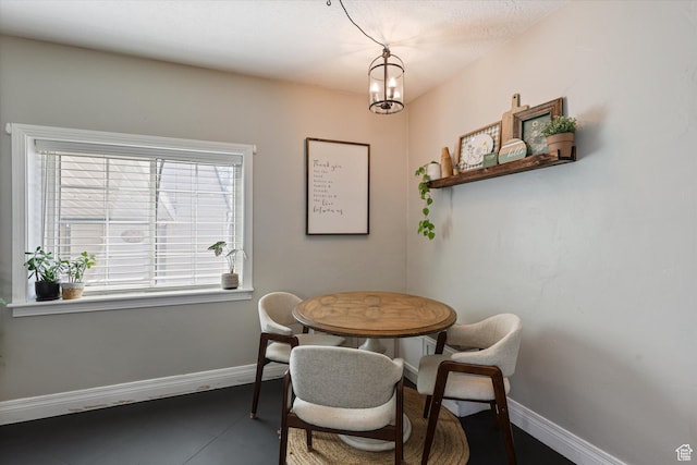 dining area with baseboards and a notable chandelier