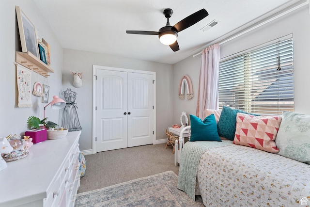 carpeted bedroom featuring baseboards, visible vents, a closet, and ceiling fan