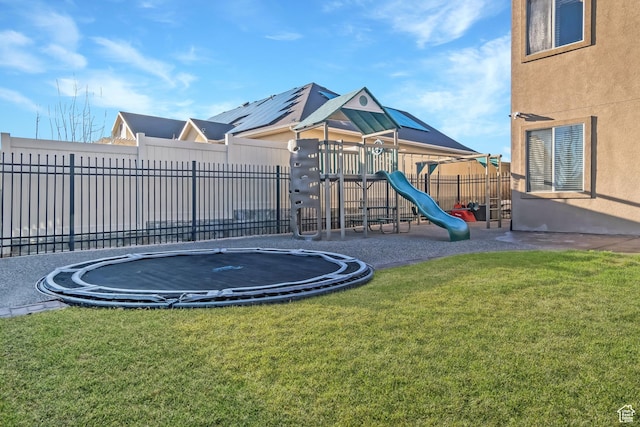 community playground with a lawn, fence, and a trampoline