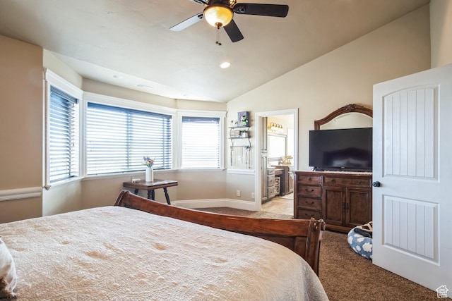 bedroom featuring light carpet, multiple windows, vaulted ceiling, and ensuite bath