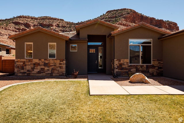 484 E Mohawk Dr, Kanab, UT 84741 - view of front of house with stucco siding, a tile roof, a mountain view, and stone siding