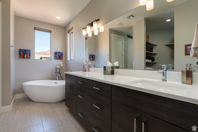 484 E Mohawk Dr, Kanab, UT 84741 - full bath featuring visible vents, baseboards, double vanity, a freestanding tub, and a sink