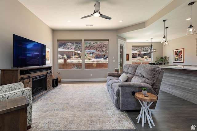 484 E Mohawk Dr, Kanab, UT 84741 - living area with baseboards, visible vents, a ceiling fan, a fireplace, and wood finished floors
