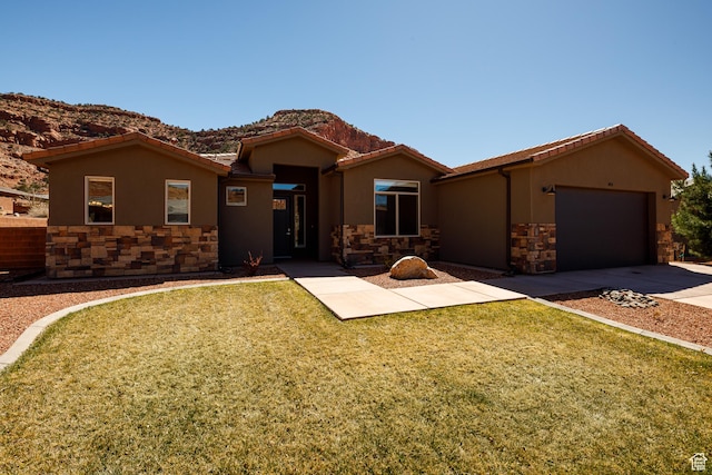 484 E Mohawk Dr, Kanab, UT 84741 - view of front facade featuring a tile roof, a front yard, concrete driveway, stucco siding, and a garage