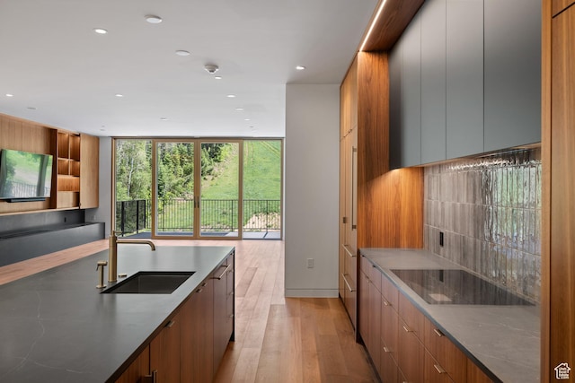 3267 W Deer Hollow Rd Unit 2402, Park City, UT 84060 - kitchen with modern cabinets, black electric stovetop, light wood-style flooring, recessed lighting, and a wall of windows