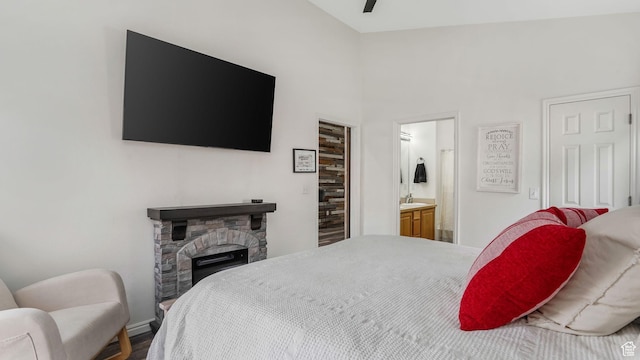 1138 S Meadow Fork Rd E Unit 3, Provo, UT 84606 - bedroom with a stone fireplace, a sink, connected bathroom, baseboards, and wood finished floors