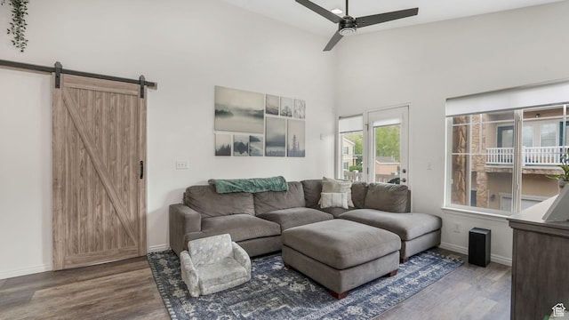 1138 S Meadow Fork Rd E Unit 3, Provo, UT 84606 - living room featuring a barn door, wood finished floors, ceiling fan, baseboards, and a towering ceiling
