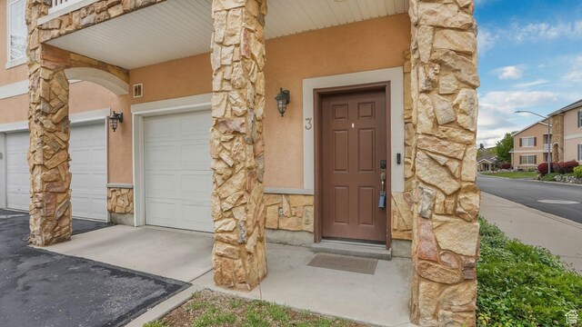 1138 S Meadow Fork Rd E Unit 3, Provo, UT 84606 - doorway to property with stone siding, stucco siding, and a garage